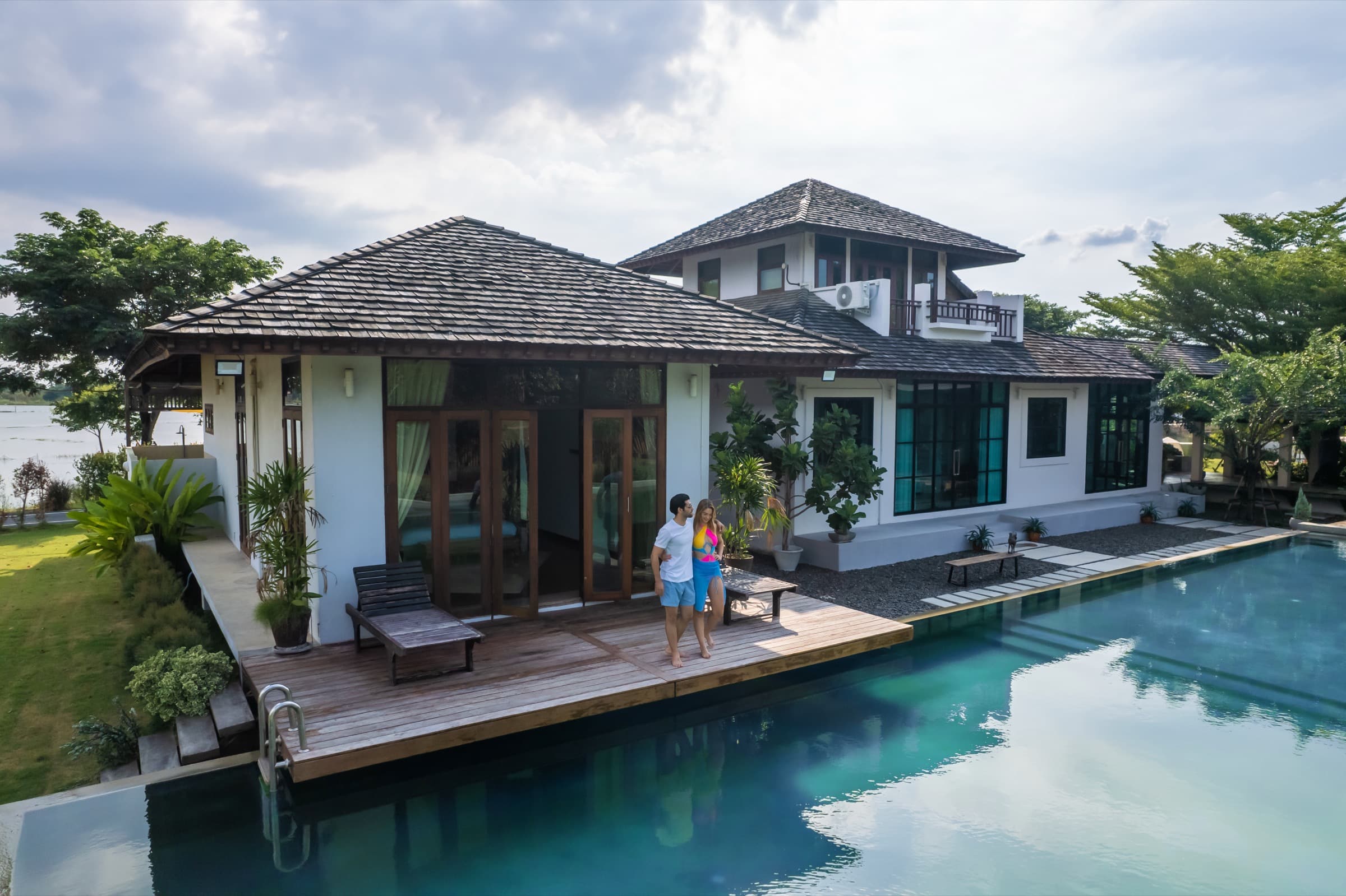 Couple on the pool deck of a tropical villa